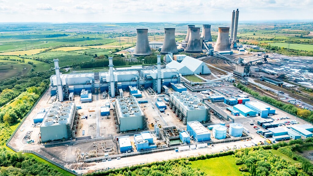 Aerial view of a gas-fired power plant with cooling towers and surrounding energy infrastructure