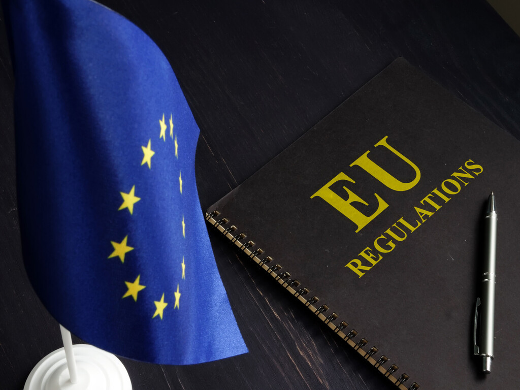 EU gas import rules illustrated by a European Union flag and an EU regulations notebook