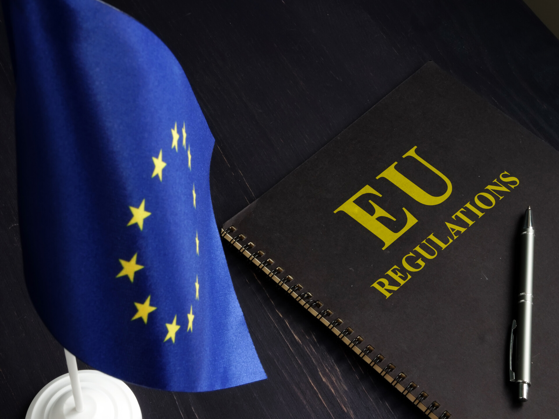 EU gas import rules illustrated by a European Union flag and an EU regulations notebook